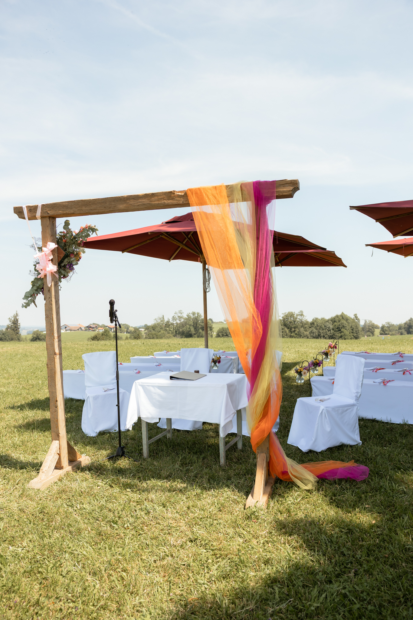 Traubogen und gedeckte Tische bei einer Gartenhochzeit