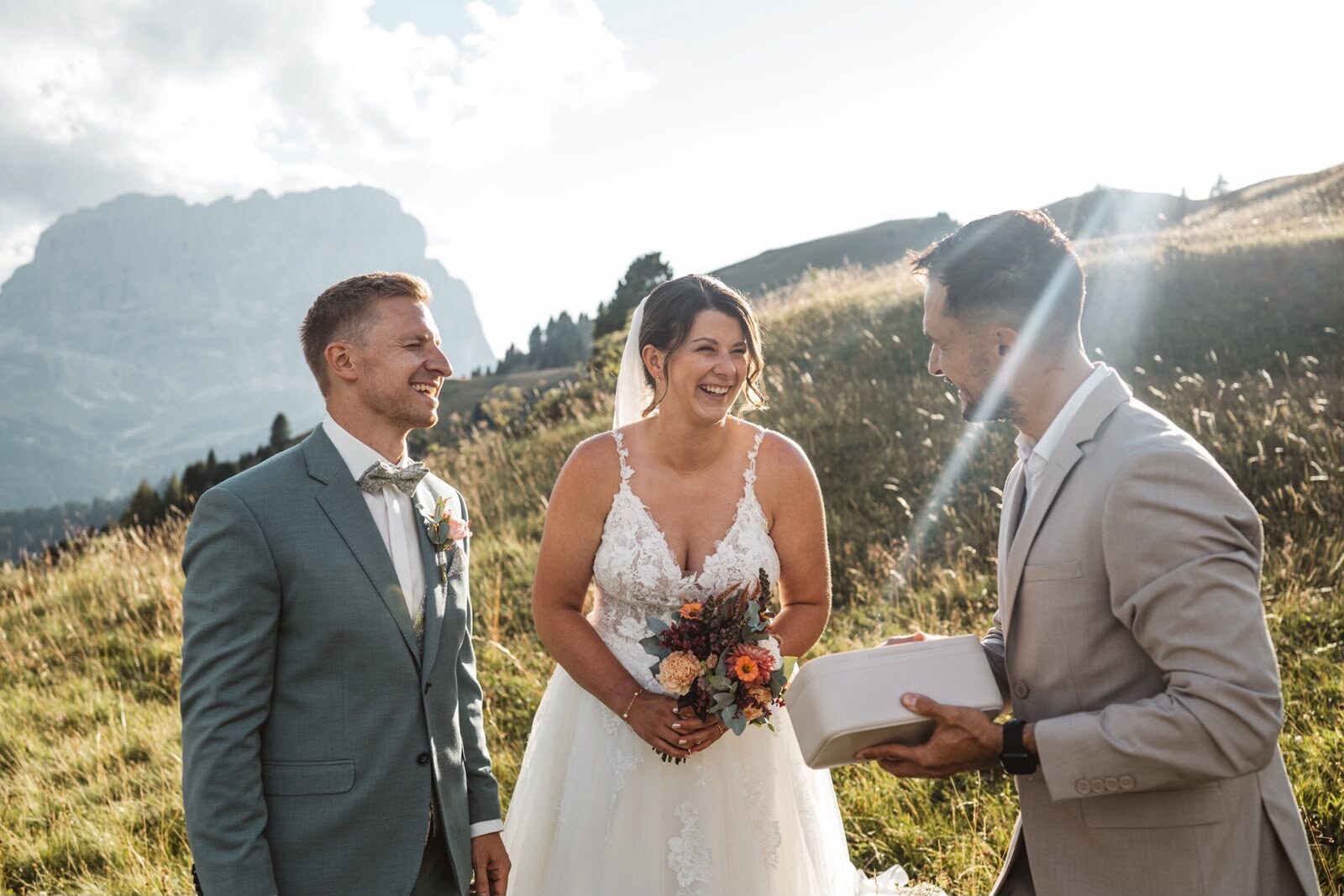 Brautpaar beim Elopement in den Dolomiten, der Redner reicht die Ringe