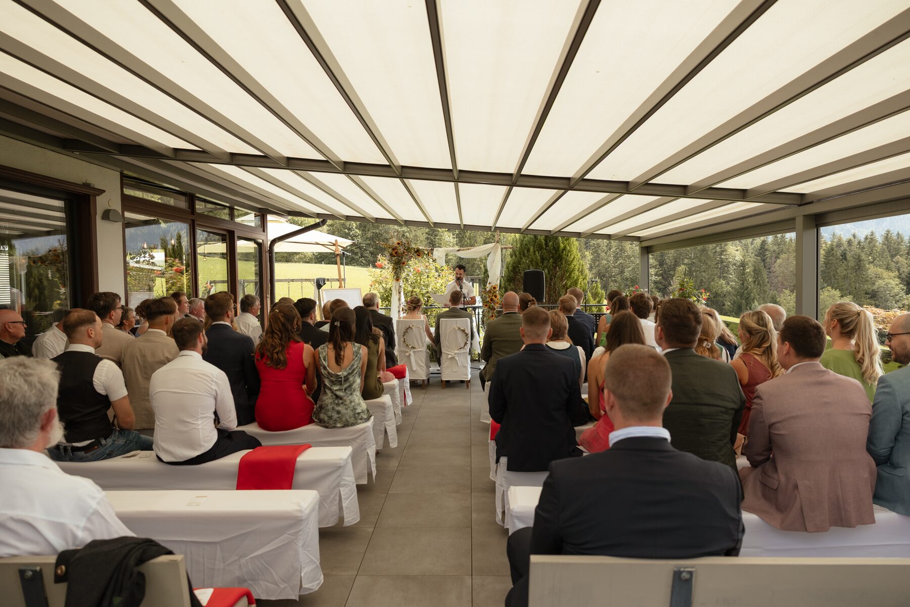 Gäste auf der überdachten Terrasse bei der freien Trauung im Zacherl in Ebbs