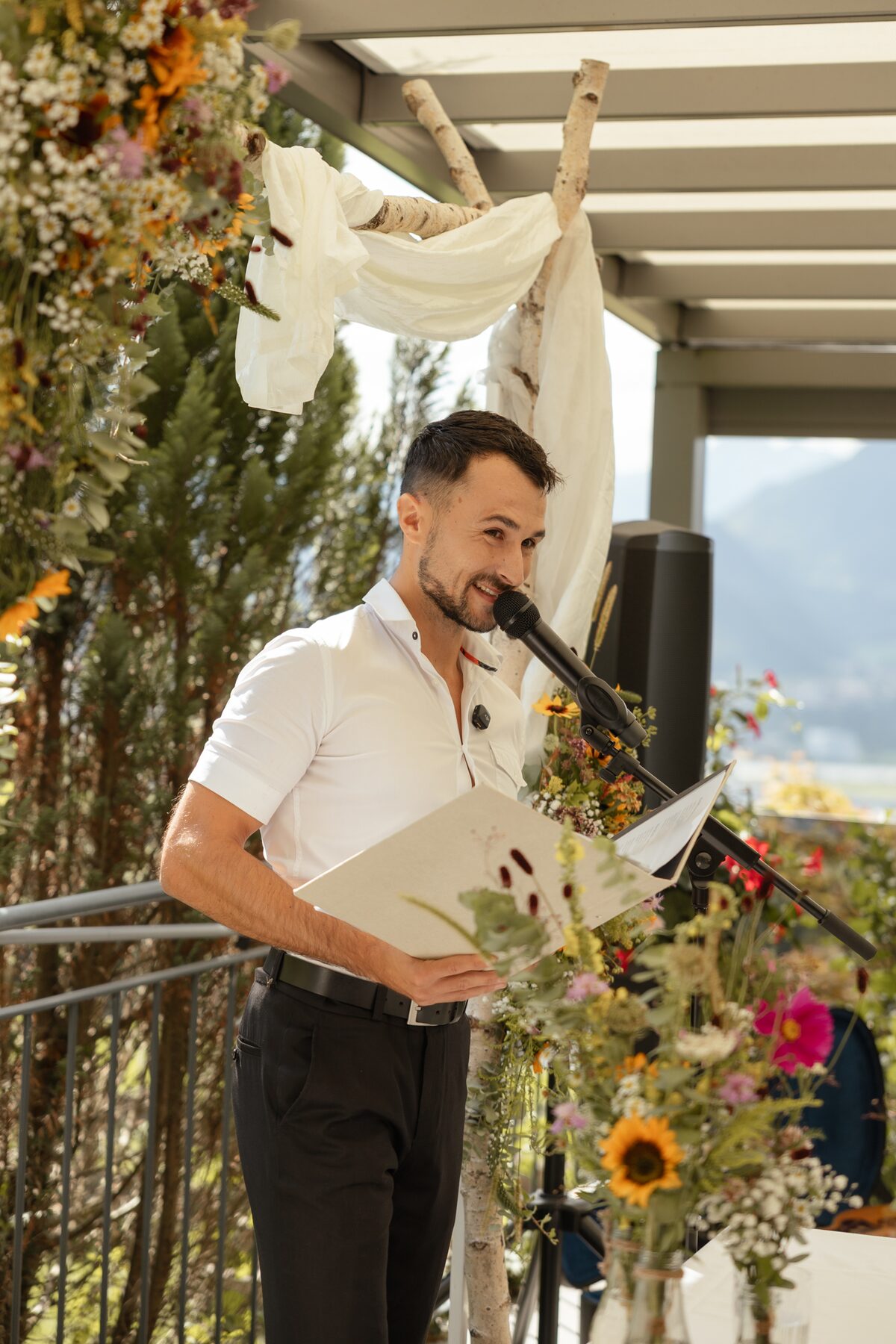 Freier Redner Alex am Mikrofon vor Sonnenblumen im Zacherl in Ebbs