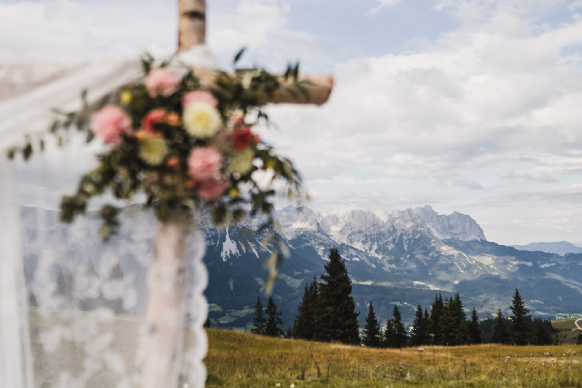 Blumenschmuck am Traubogen der Tanzbodenalm mit Blick in die Berge