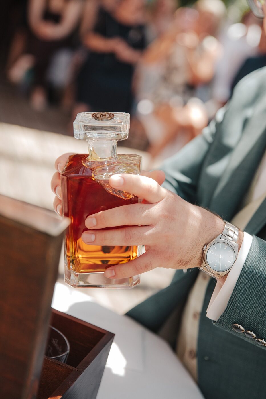 Brautpaar stößt mit Whisky aus der gravierten Flasche an